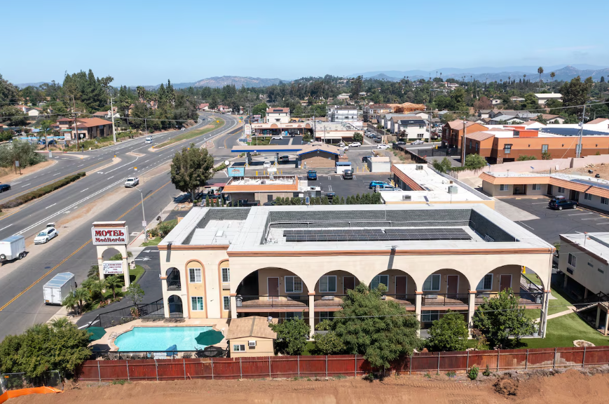 Aerial wide view of the motel along the highway with hills on the horizon
