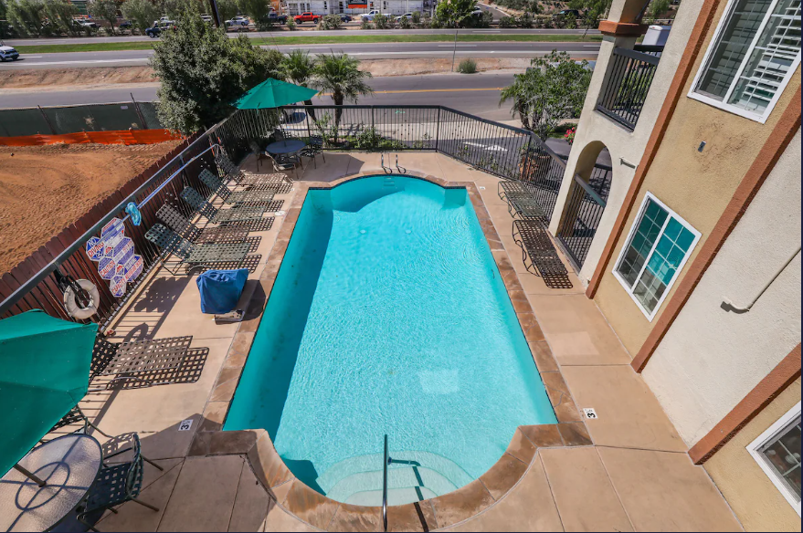 Overhead view of the rectangular outdoor pool and patio loungers from a balcony