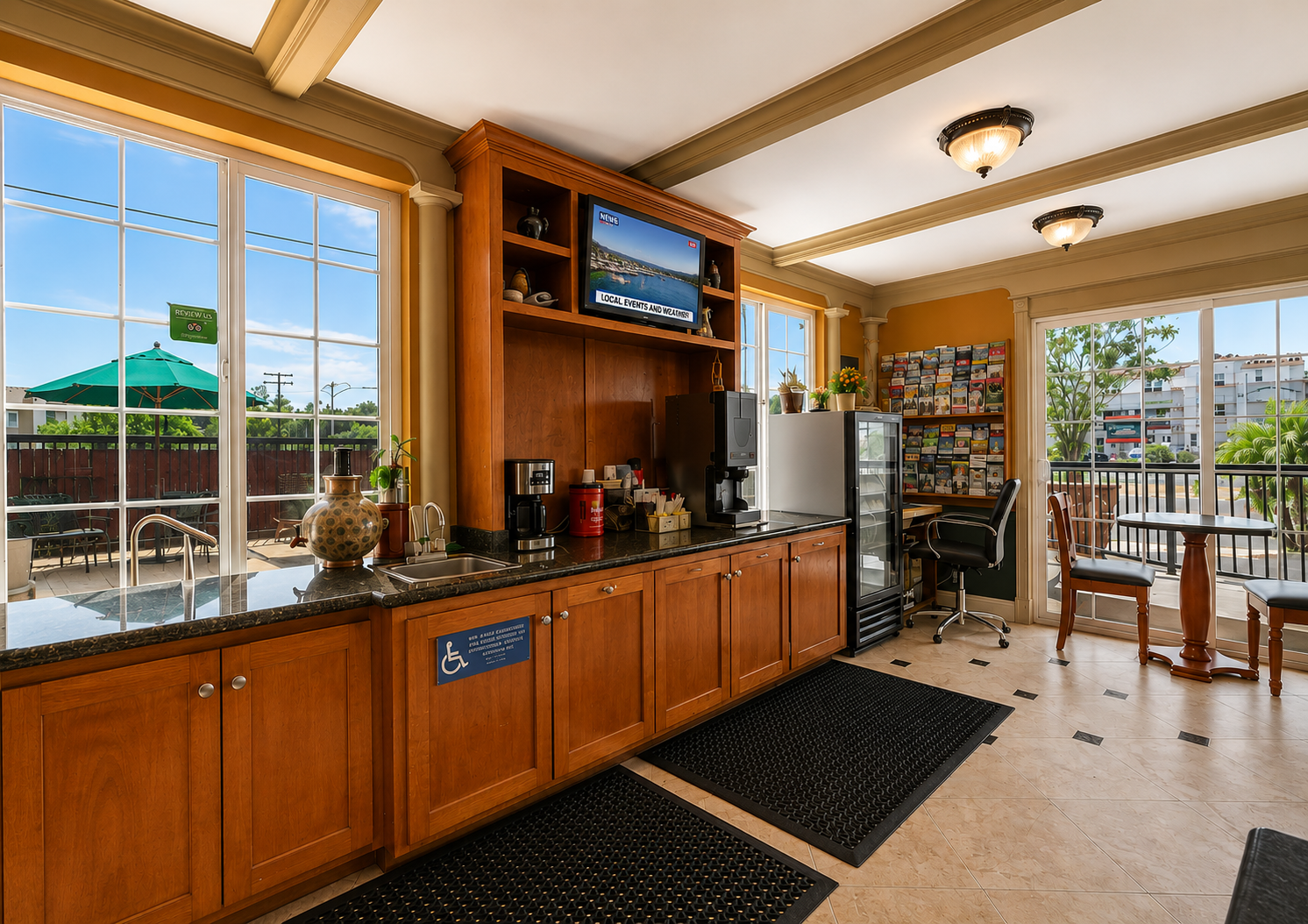 Breakfast and coffee station with brochures, fridge, and patio seating beyond