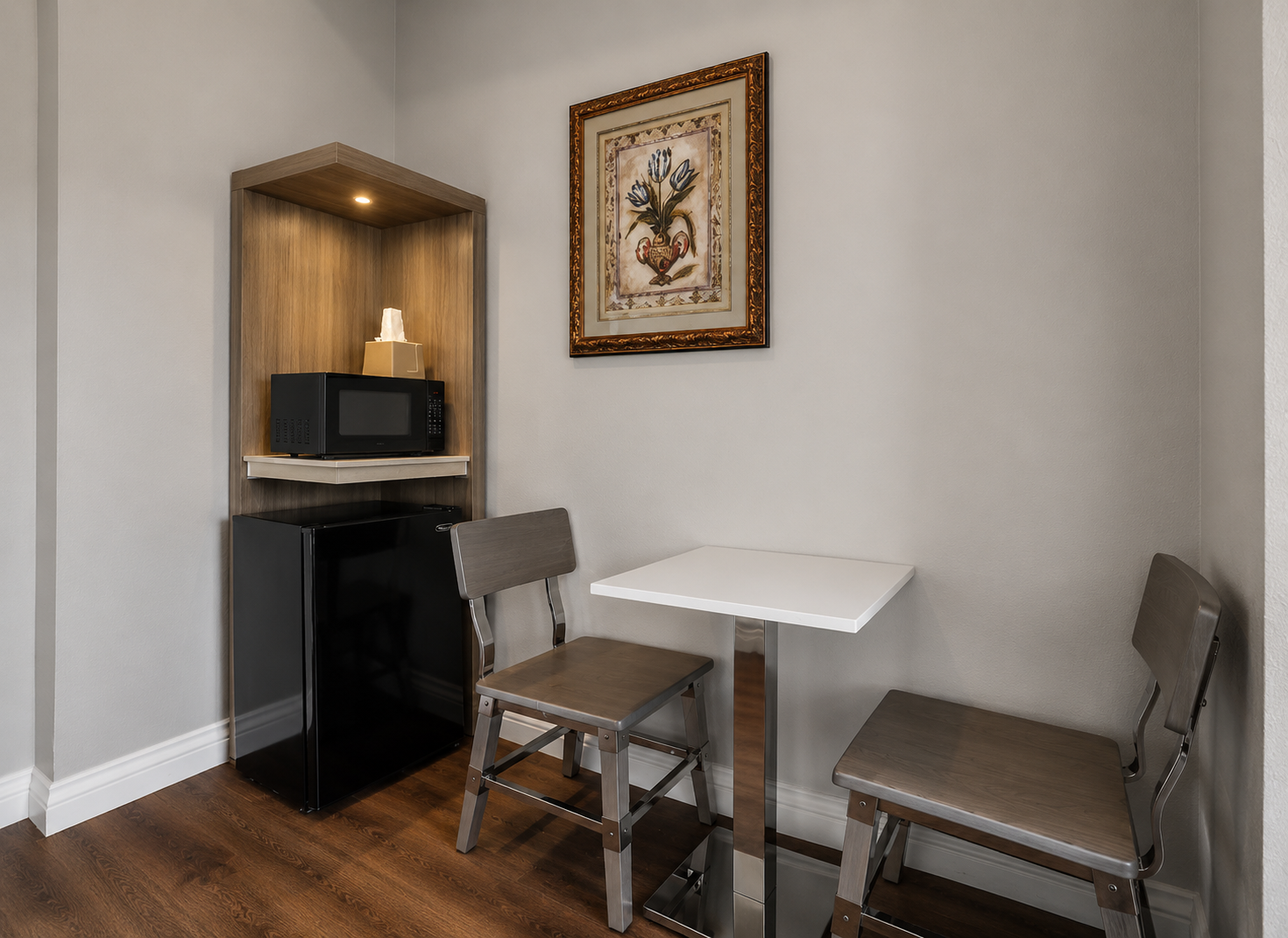 In-room dining nook with table, chairs, mini-fridge, and microwave alcove