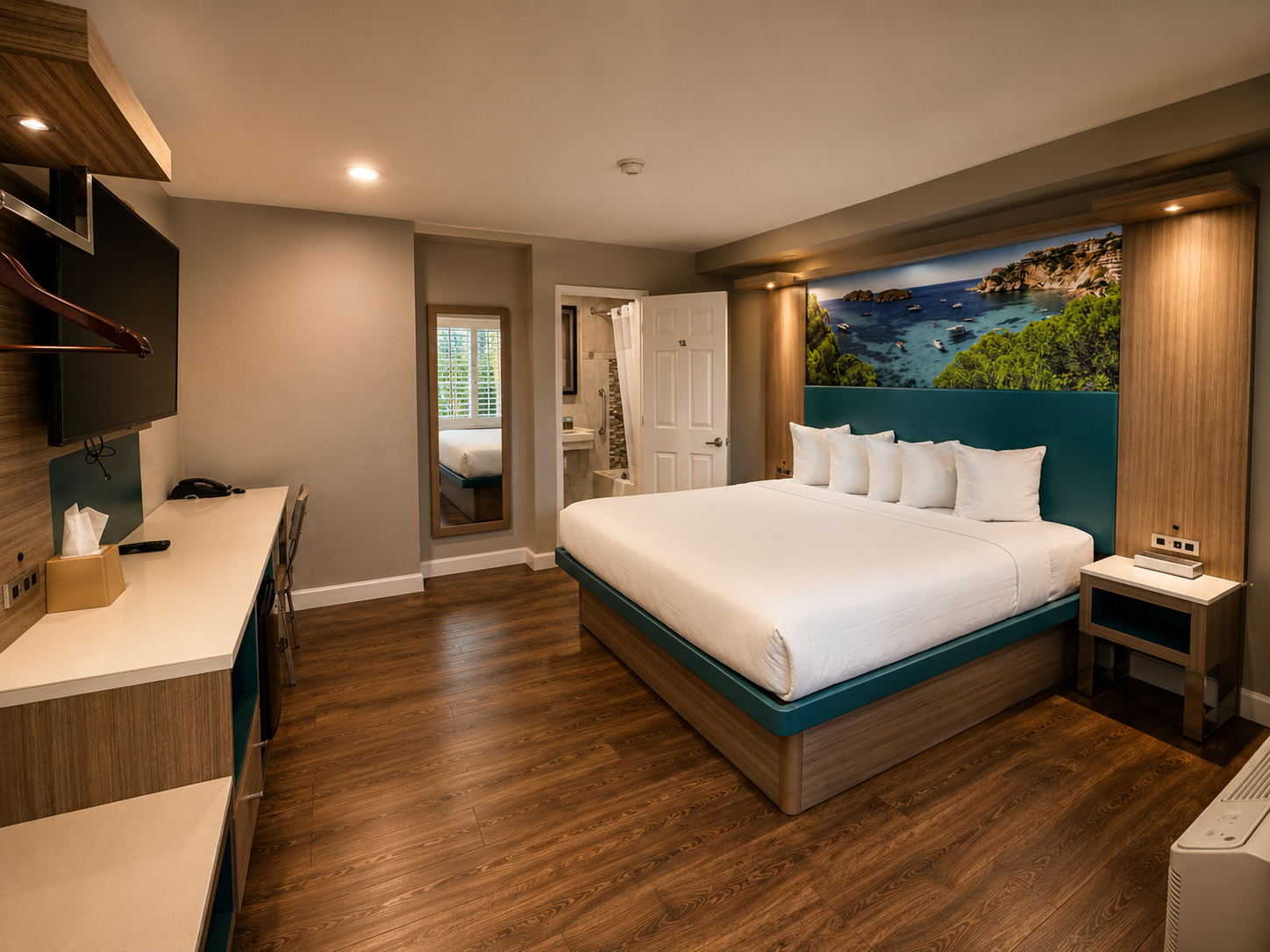 Standard King room from the desk corner with mirror, bathroom, and king bed