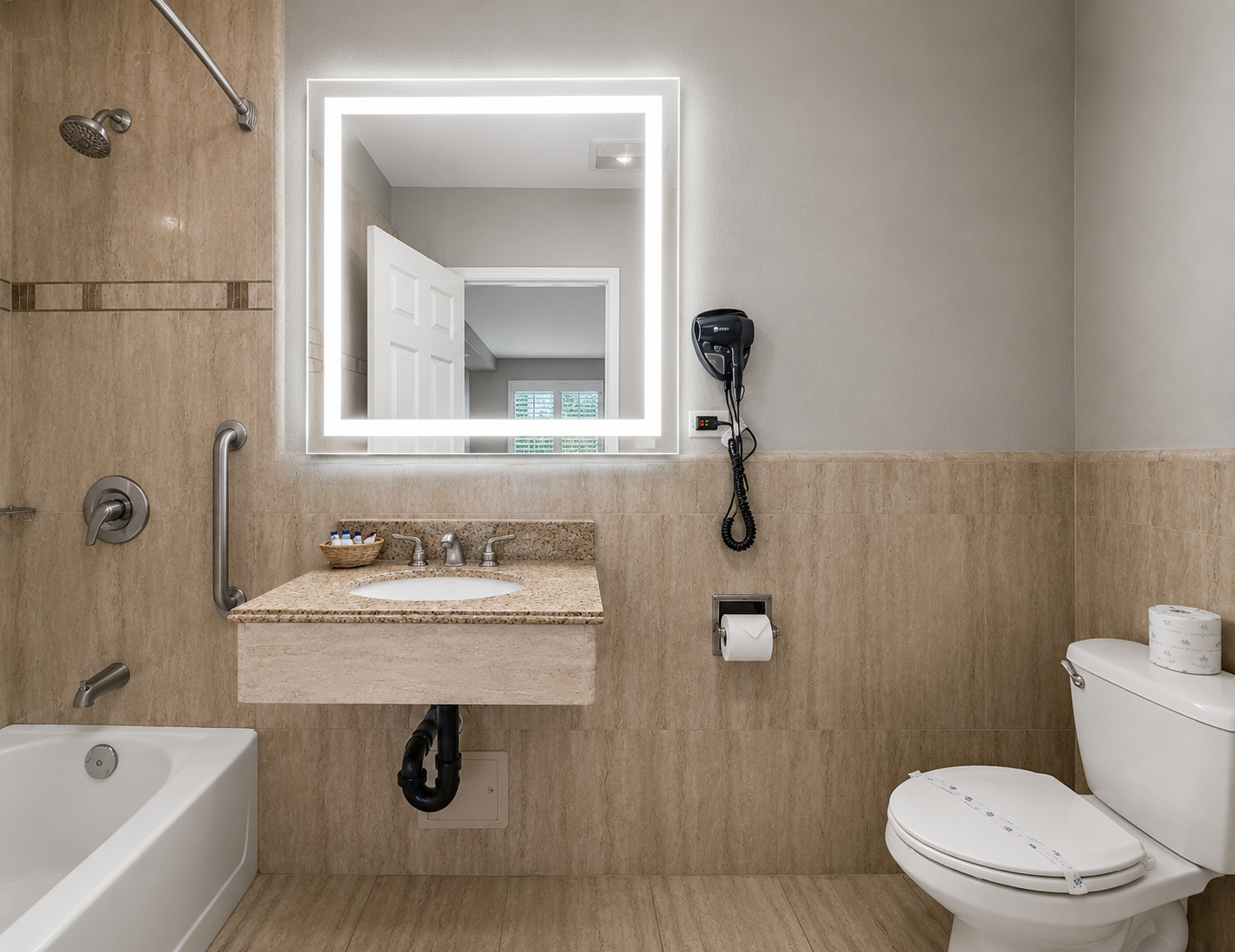 Standard King bathroom interior with toilet, sink vanity, and lit mirror