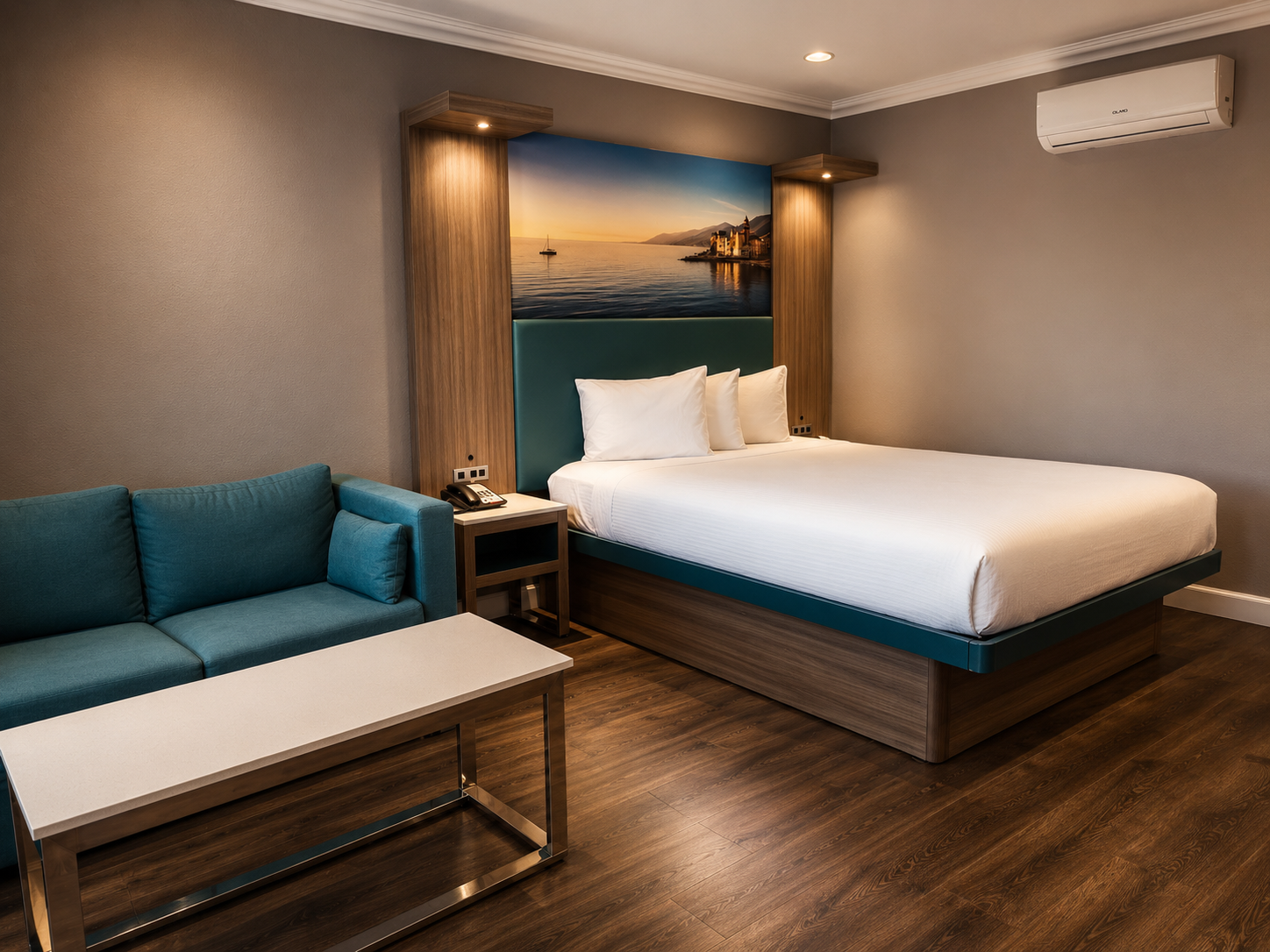 Standard Queen room with sunset coastal mural, queen bed, and teal sofa