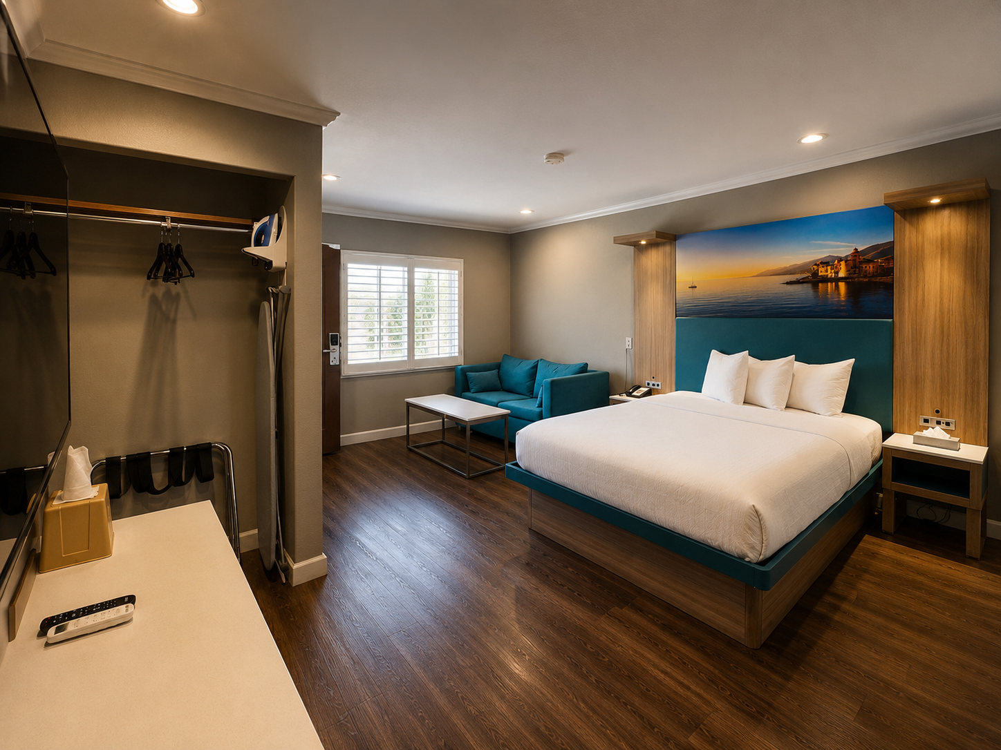 Standard Queen room with open closet, armchair, and seaside artwork above the bed